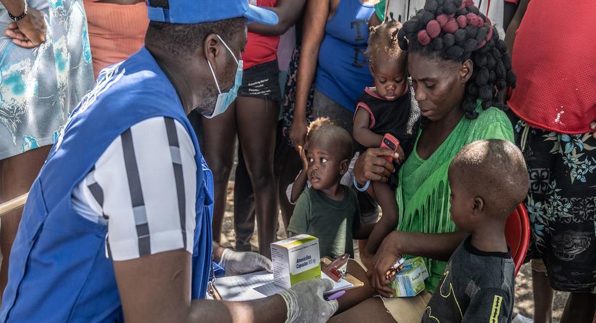 Un trabajador de la ONU brinda cuidados de salud a una mujer y a niños desplazados. | Foto: UNOCHA/Giles Clarke