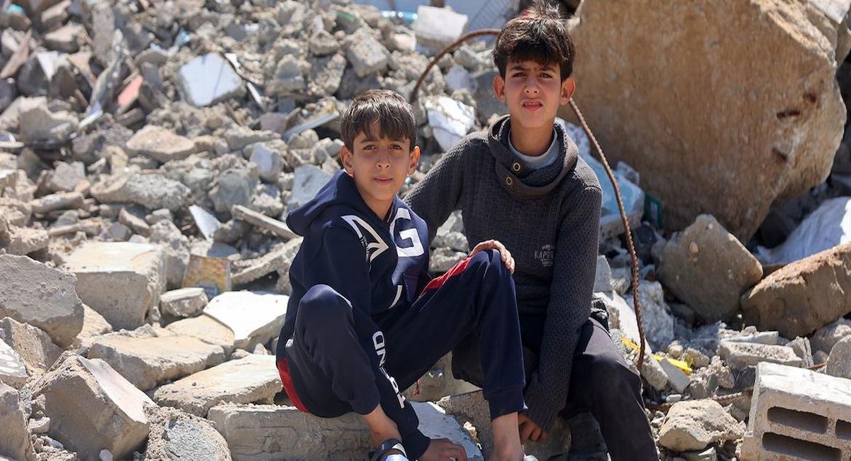 Niños palestinos sentados entre los escombros de las casas destruidas en el campo de Yabalia, al norte de Gaza. | Foto: ONU