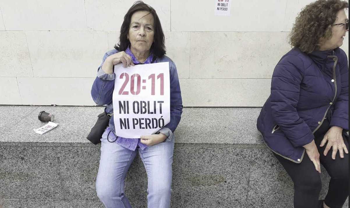 Una mujer participa en la protesta de los valencianos contra Mazón a las puertas de la Ciudad de la Justicia.