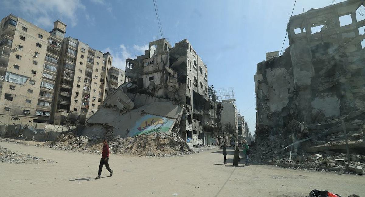 Personas recorren las calles entre escombros y edificios bombardeados en Gaza, tras la muerte de 300 palestinos. | Foto: UNFPA/Yasmeen Sous