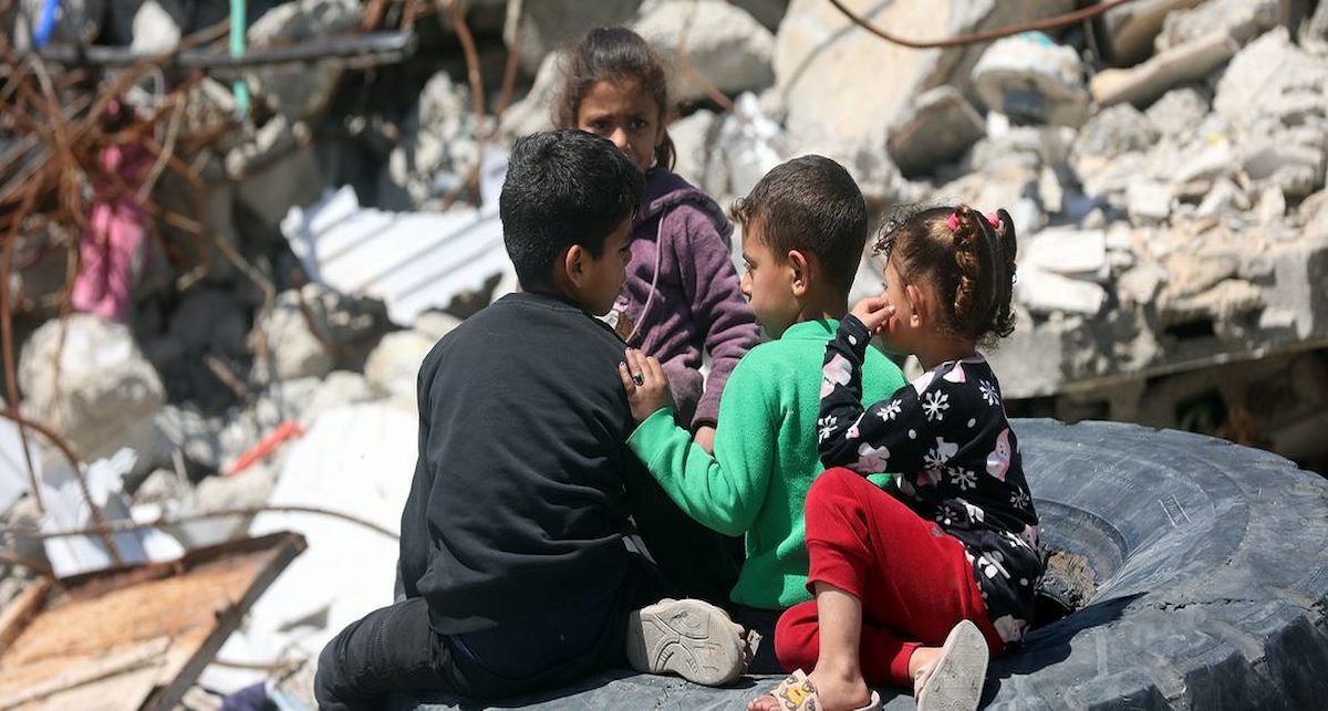 Niños palestinos sentados entre los escombros de las casas destruidas en el campo de Jabalia, al norte de Gaza. | Foto: ONU