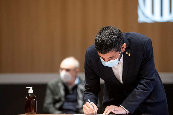 El conseller Chakir el Homrani signant l'acord