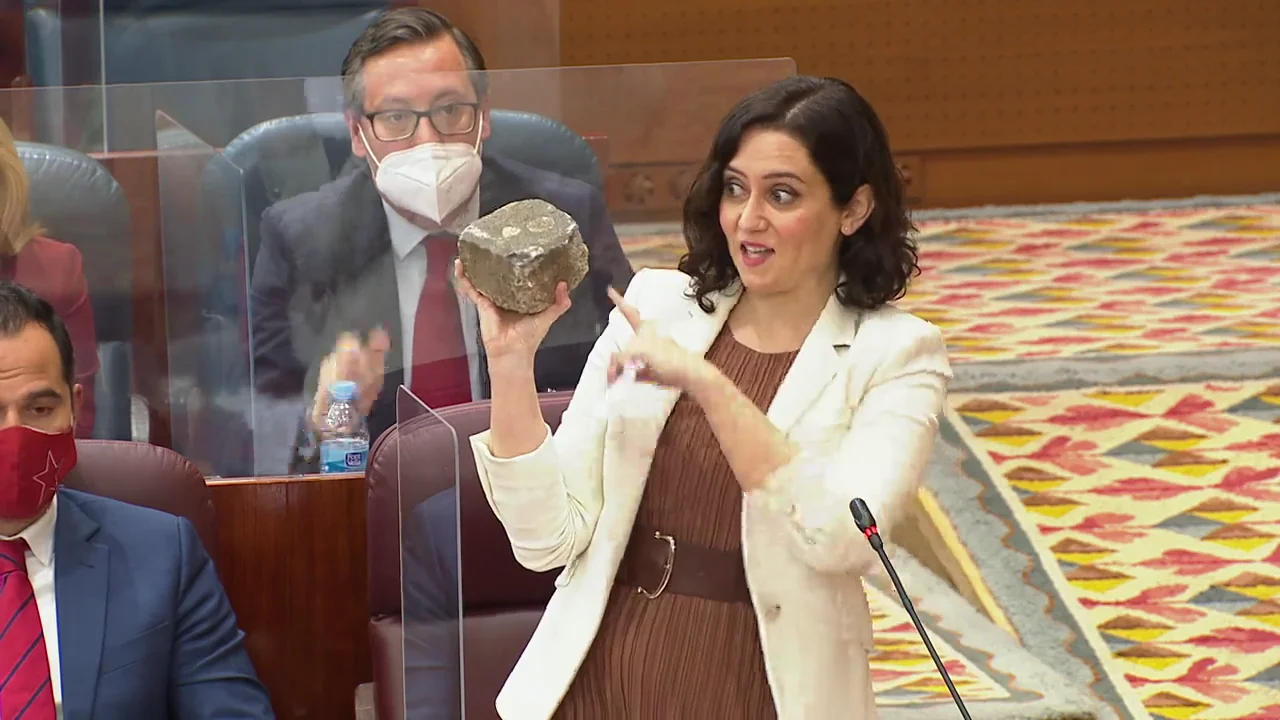 Isabel Díaz Ayuso enseña un adoquín en la Asamblea de Madrid el 18 de febrero 2021