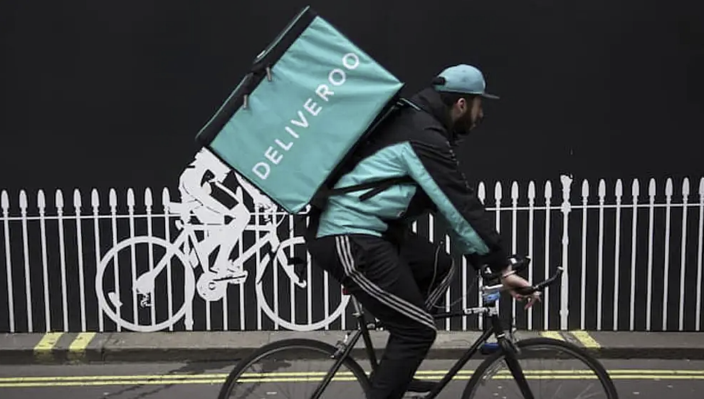 Un rider de Deliveroo repartiendo comida.